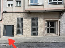Un edificio con fachada de piedra, una puerta metálica con un panel de vidrio y un letrero con el número 3 sobre la puerta.