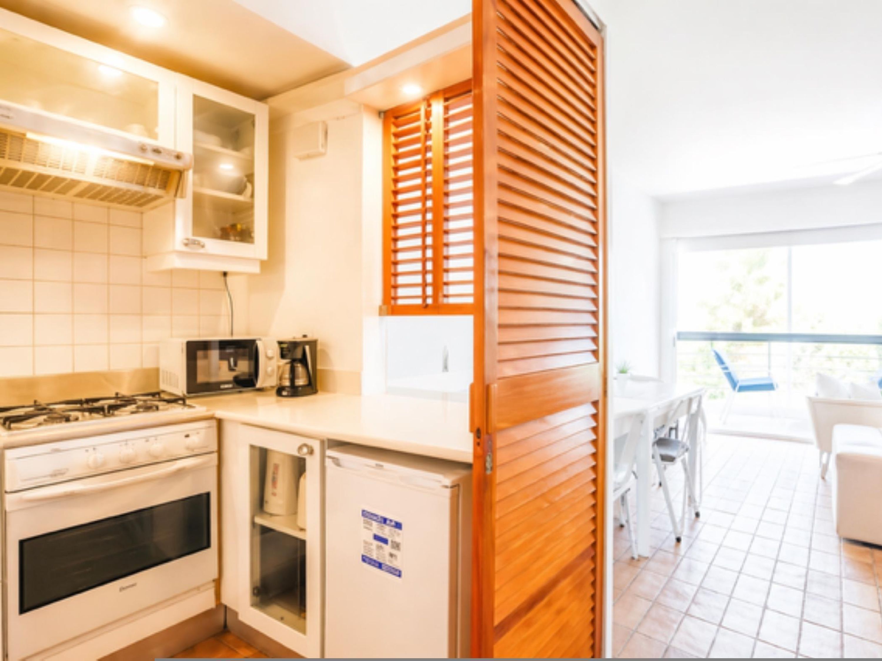 Una cocina equipada con estufa, microondas y cafetera.