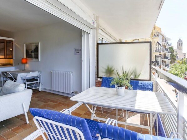 A balcony with a table, chairs, and a potted plant. - Frenta al mar Reci n Reformado Pen Lope (Sitges)