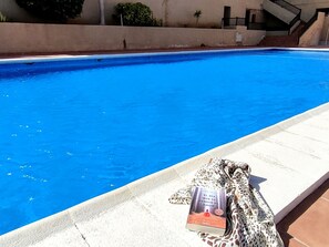 A swimming pool with a book on the edge. - CM 2 bd Cerca del mar (Granadilla de Abona)