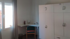 A room with a white desk, a chair, and a wardrobe. - Luminous Flat in Great Location (Valencia)