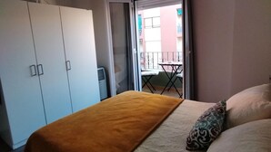 A bedroom with a bed, a wardrobe, and a balcony with a table and chairs. - Luminous Flat in Great Location (Valencia)