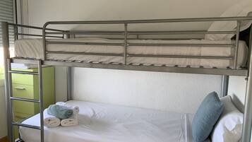 Una cama litera con un armario verde y una escalera.