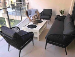 A modern living room with a sofa, two armchairs, and a coffee table.