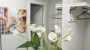 A bathroom with a large mirror, a sink, and a hanging clothes rack. - Bonito Apartamento en Centro Ciudad con Garaje (Albaida)