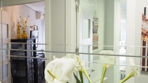 A modern bathroom with a glass partition, a white flower arrangement, and a visible shower area. - Bonito Apartamento en Centro Ciudad con Garaje (Albaida)