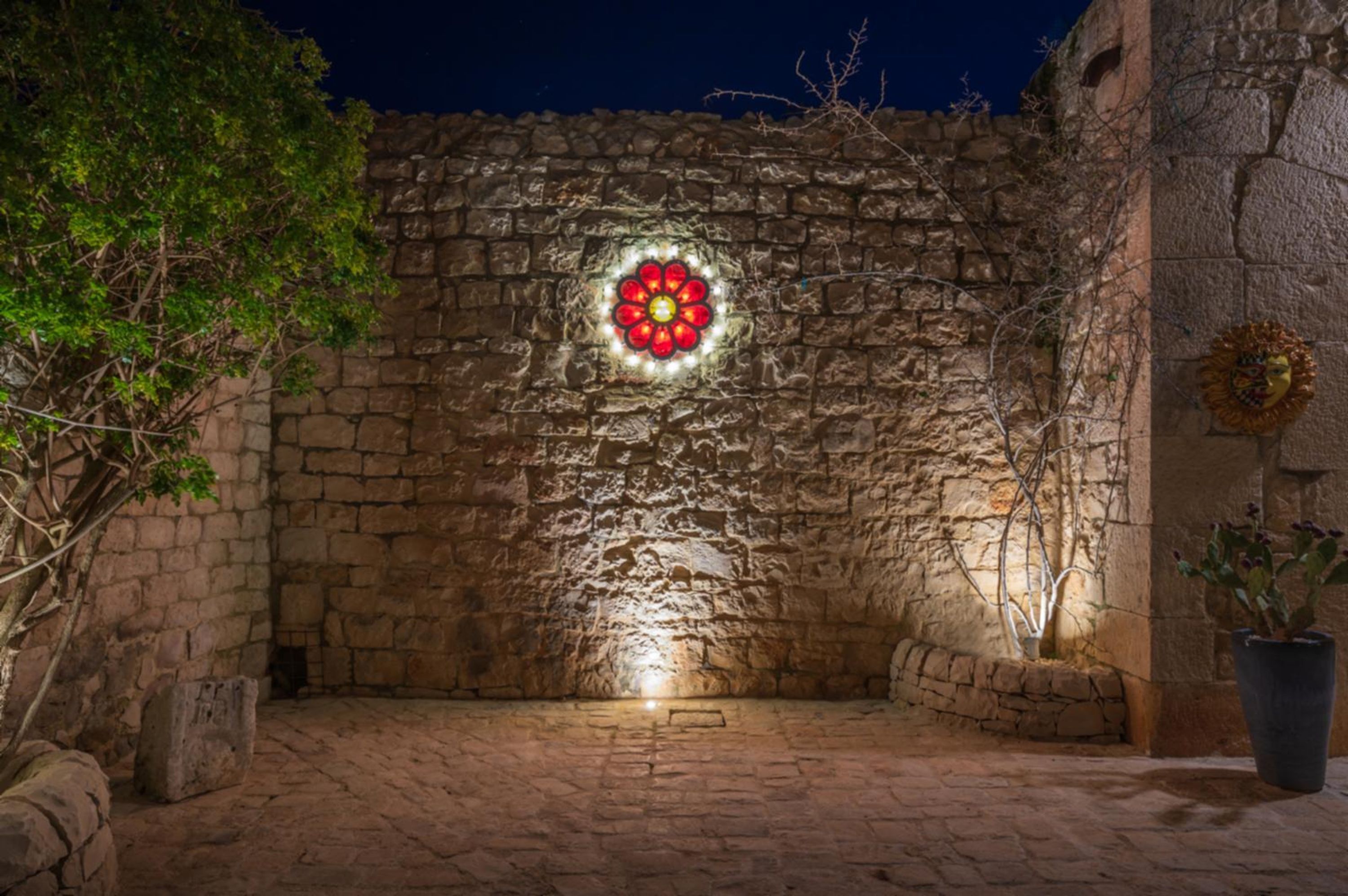 A stone courtyard with a decorative light fixture and a potted plant.
