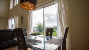 A dining area with a glass table, black chairs, a laptop, and a view of the outdoors. - Cheerful 5 bed - 4 Bath Spacious Home (Kissimmee)