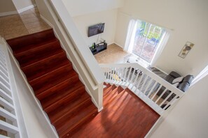 A staircase leading to a living area with a television, a window with curtains, and a view of the outdoors. - Cheerful 5 bed - 4 Bath Spacious Home (Kissimmee)