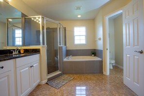 A bathroom with a shower enclosure, a bathtub, and a toilet. - Cheerful 5 bed - 4 Bath Spacious Home (Kissimmee)