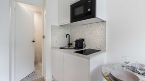 A compact kitchen with a built-in microwave, a coffee maker, and a sink. - Bright Studio - 2P - Beaugrenelle/eiffel Tower (Paris)
