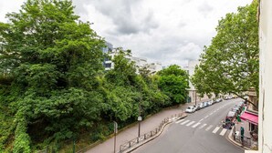 A street with a pedestrian crossing, lined with trees and parked cars. - Bright Studio - 2P - Beaugrenelle/eiffel Tower (Paris)