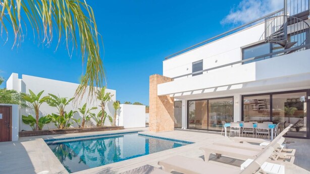 A modern outdoor pool area with lounge chairs and a dining area. - Villa Sa Marinada Modern Villa With Pool for 8 People (Sant Josep de sa Talaia)