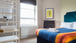 A bedroom with a bed, a wardrobe, a radiator, a window, and a picture on the wall. - Cool Covent Garden 1BR - Netflix Nespresso (London)