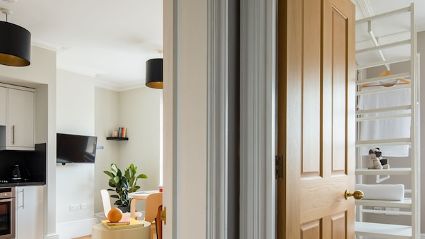 A modern kitchen with white cabinets, a black countertop, and a built-in oven. - Cool Covent Garden 1BR - Netflix Nespresso (London)