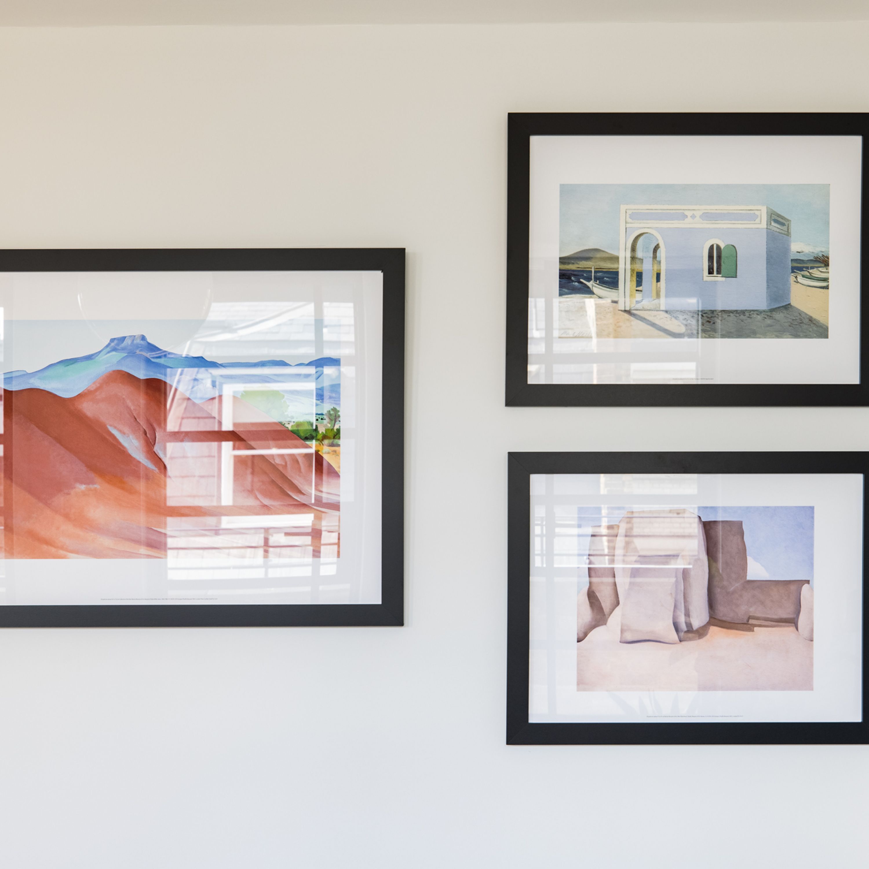 Tres obras de arte enmarcadas en una pared.