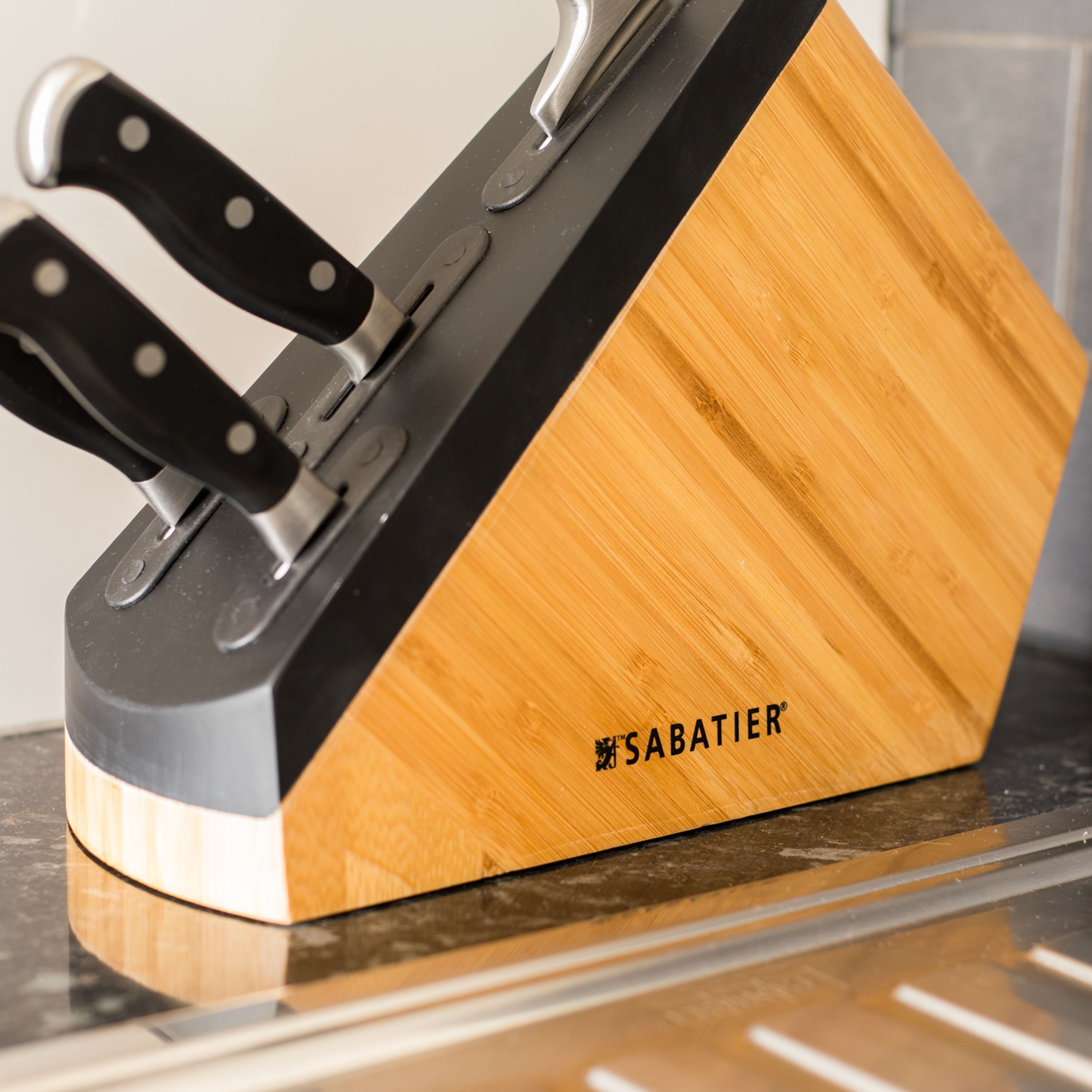 A kitchen knife block with a wooden base and metal handles.