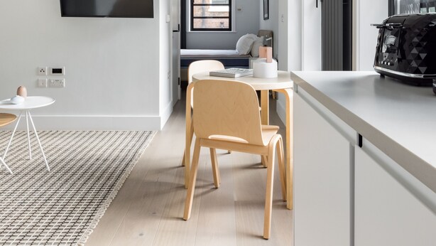 Een moderne keuken met een eethoek, een flatscreen televisie aan de muur en een groot raam voor natuurlijk licht.