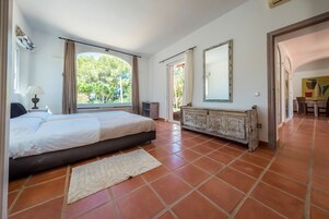 Un dormitorio con cama, cómoda y ventana con cortinas.