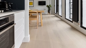 A modern kitchen with a built-in stove, a dining area with a table and chairs, and a large window with black shutters. - Vibrant Leicester Square 2BR - Netflix Nespresso (London)