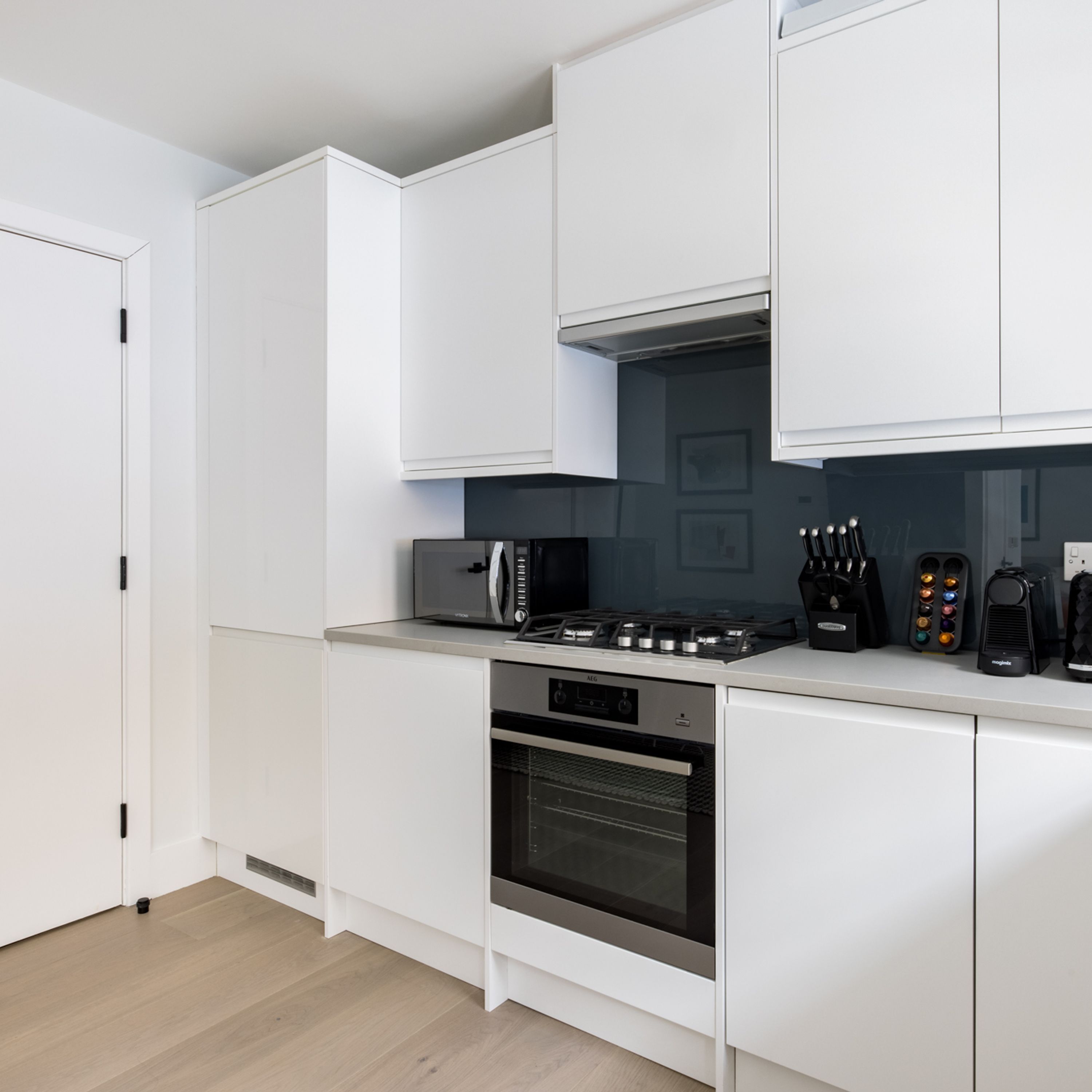 A modern kitchen with white cabinetry, a microwave, a gas stove, and an oven.