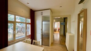 A kitchen with a refrigerator, cabinets, and a dining table. - Galata Port Flats Chakra 2 (Istanbul)