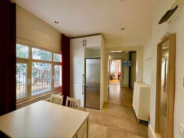 A kitchen with a refrigerator, cabinets, and a dining table. - Galata Port Flats Chakra 2 (Istanbul)
