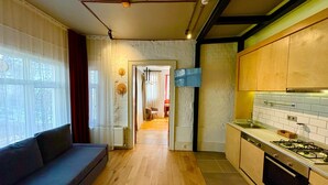 A modern kitchen with wooden flooring, a built-in stove, and a dining area with a table and chairs. - Galata Port Flats Chakra 2 (Istanbul)