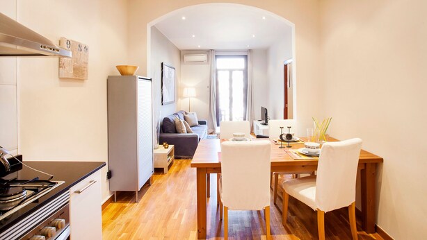 Une cuisine moderne équipée d’une cuisinière, de placards et d’un coin repas avec une table et des chaises.
