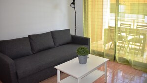 A modern living room with a grey sofa, a white coffee table, and a small potted plant. - Apartament Sergi in Amposta (Amposta)