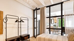 A bedroom with two beds, a wardrobe, and a large window with curtains. - Sant Mori- La Escala Boutique Apartment (Sant Mori)