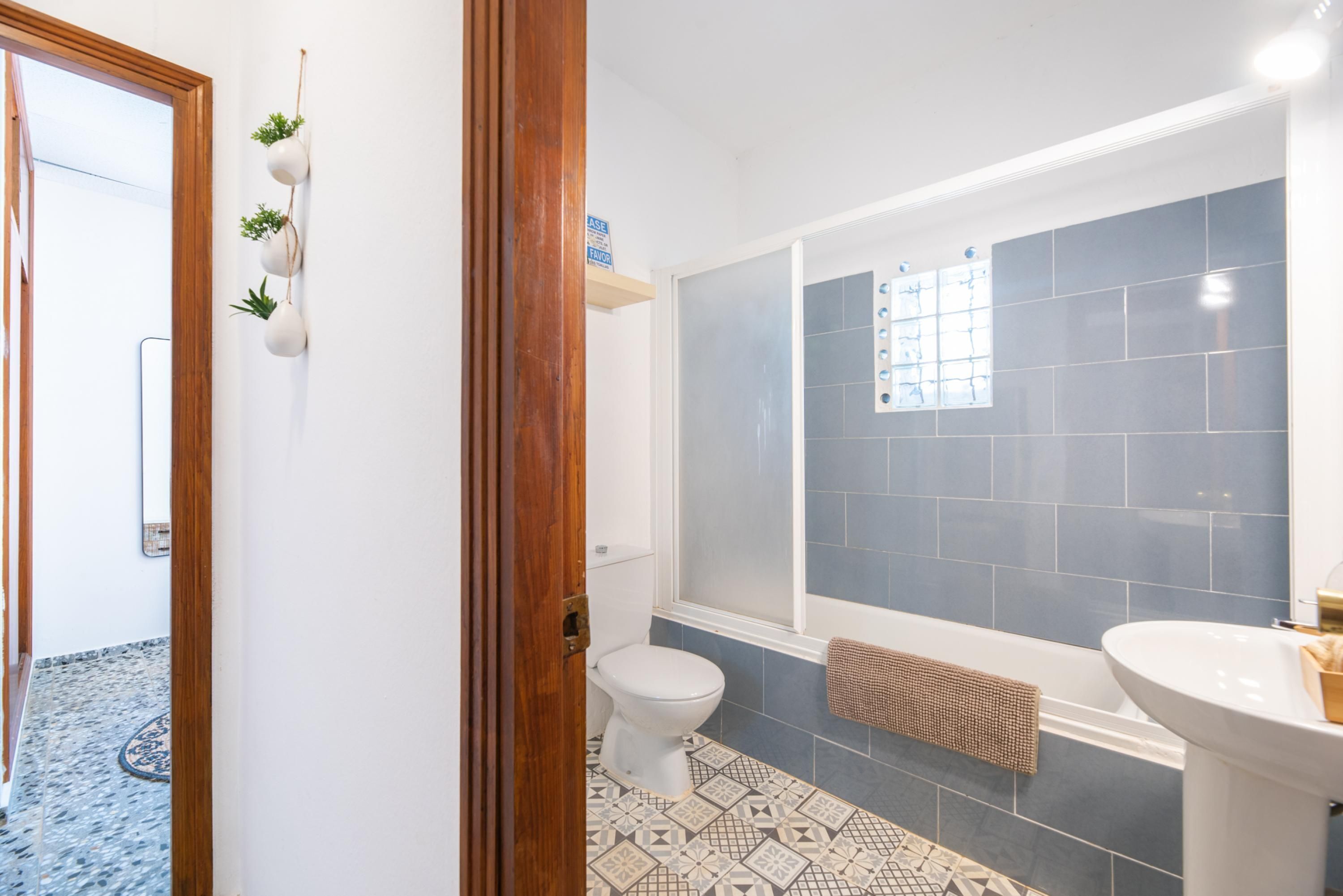 Et badeværelse med toilet, badekar og vask.