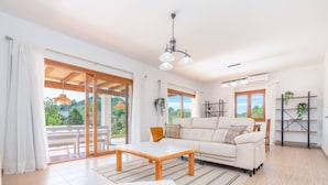 A spacious living room with a sofa, a wooden coffee table, and a dining area. - Villa Sa Planeta in Sant Josep de Sa Talaia (Sant Josep de sa Talaia)