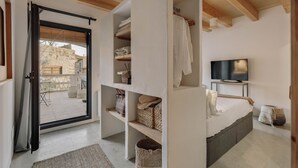 Une chambre à coucher avec un lit, une télévision et des étagères intégrées.