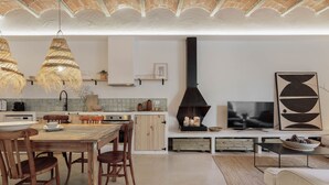 Une cuisine moderne avec un coin repas, une cheminée et un téléviseur.