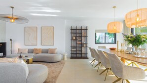 A modern living room with a sofa, a coffee table, and a dining area with chairs and a table. - Can Palau in Santa Eul ria des Riu (Santa Eulalia del Rio)