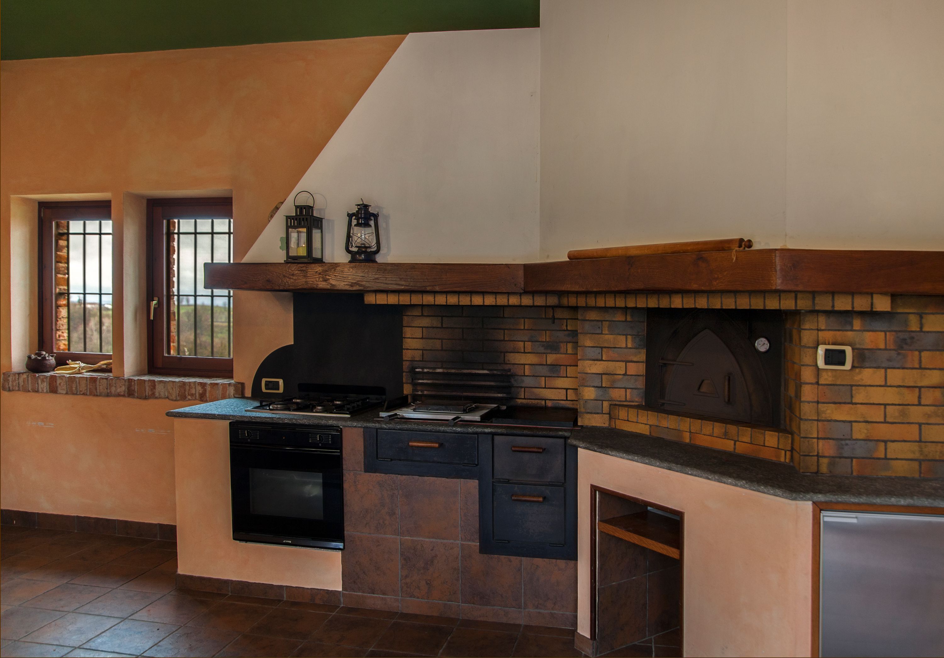 A kitchen with a brick backsplash, a built-in oven, and a refrigerator.