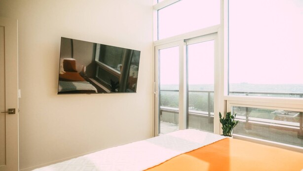 Une chambre avec un grand lit, une fenêtre donnant sur un beau paysage et un tableau accroché au mur.