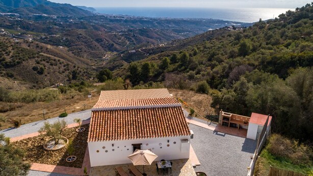 A villa with a tiled roof, a swimming pool, and a patio area with outdoor furniture. - Villa El Retiro in Frigiliana (Torrox)