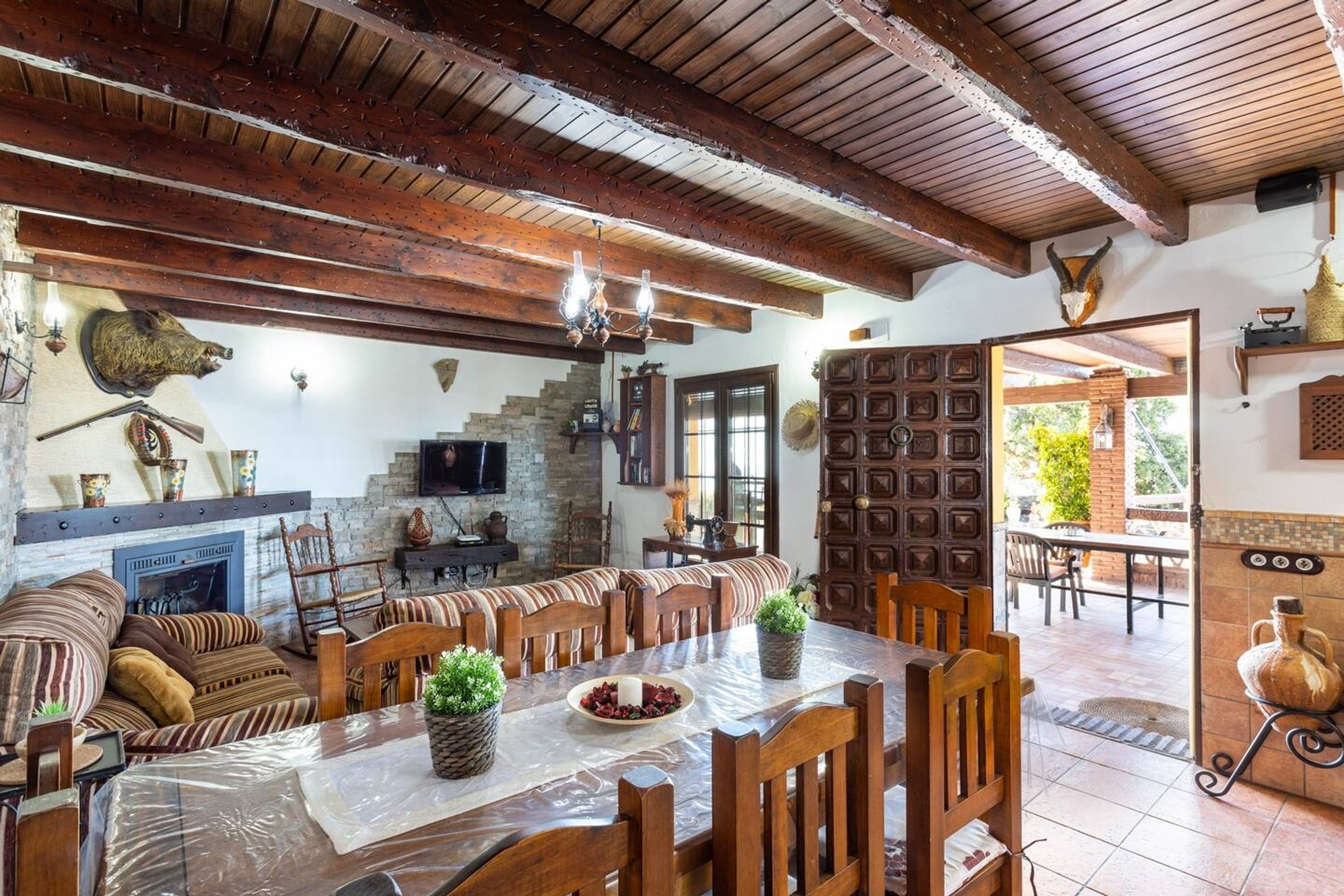 Un comedor rústico con muebles de madera, chimenea y pared de piedra.