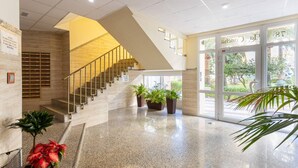 A modern hotel lobby with a marble floor, a staircase, and potted plants. - Apartamento Torrox Playa Solset (Torrox)