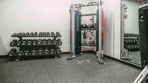 A gym with weight racks, dumbbells, a squat rack, and a mirror. - 903 (Halifax)