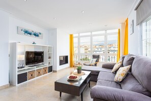 A modern living room with a sofa, TV, and entertainment unit.