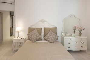 Un dormitorio con cama, mesita de noche, cómoda y espejo.