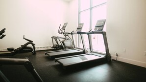 A gym with treadmills, a stationary bike, and a rowing machine. - 701 (Halifax)