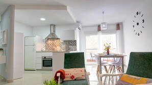 A modern kitchen with a central island, white cabinets, and a stainless steel range hood. - Apartamento Palmeras 29 Solset (Nerja)