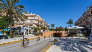 Entrada de hotel con una palmera, una estatua de Buda y un cartel para el restaurante Buddha Waves.