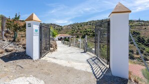 A gated entrance to a rural property with a clear path leading to a building. - Cortijo Tom Cortijo Tom Solset (Torrox)
