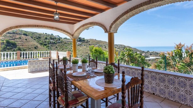 A terrace with a wooden table set for dining, surrounded by arches and a view of the countryside. - Cortijo Tom Cortijo Tom Solset (Torrox)