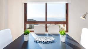 A dining area with a table, chairs, potted plants, and a view of the sea. - Villa Margarita Villa Margarita Solset (Velez-Malaga)